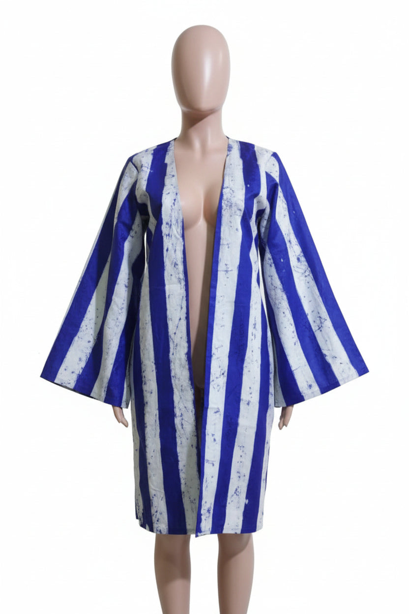 Mannequin wearing a blue and white striped dress against a beige wall.